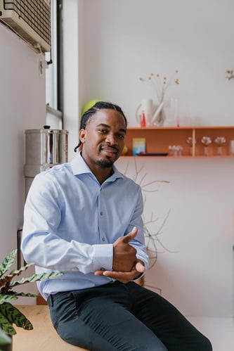 Male American Sign Language interpreter sitting on a bench signing help. Male American Sign Language interpreter sitting on a bench signing help.